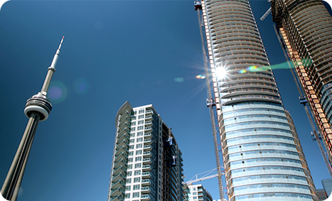 Orbit Creative video still of CN tower with sunlight reflection and apartments under construction with blue sky