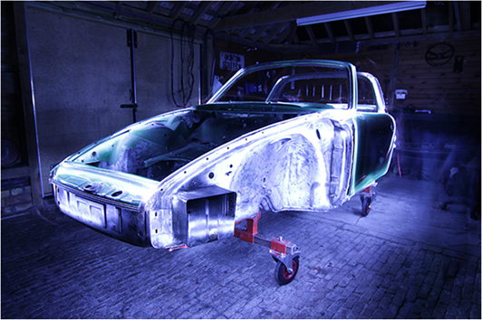 Long exposure light painting photograph taken of body of 1971 Porsche 911S Targa inside barn during restoration